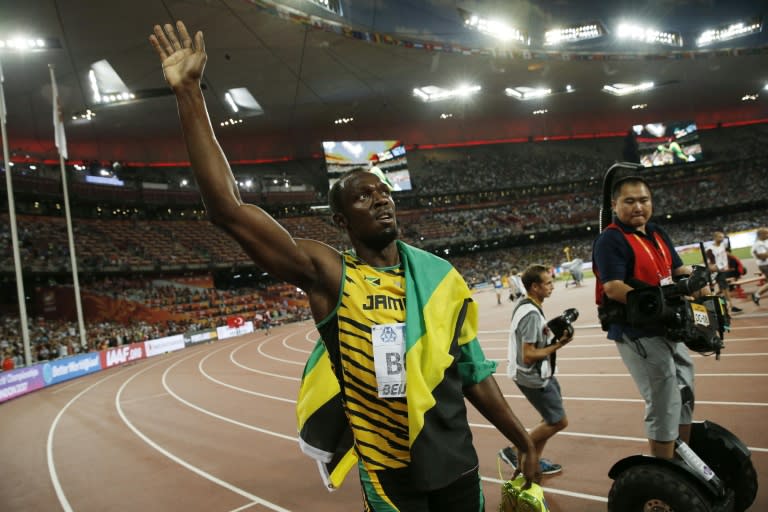 Jamaica's Usain Bolt celebrates next to a cameraman on a segway moments before the latter crashed into him after the men's 200 metres final at the IAAF World Championships at Beijing's Bird's Nest stadium on August 28, 2015