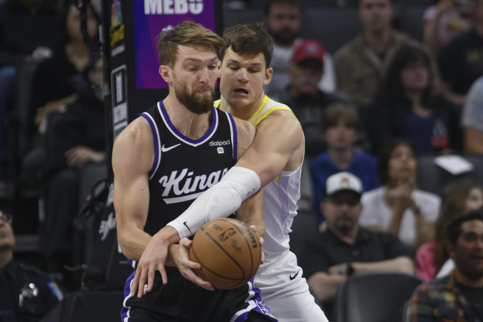 Sacramento Kings forward Domantas Sabonis, left, is guarded by Utah Jazz center Walker Kessler during the first half of an NBA basketball game in Sacramento, Calif., Sunday, March 31, 2024. (AP Photo/Randall Benton)