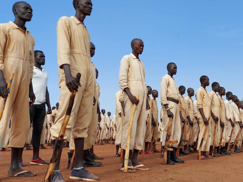 In this Saturday, June 27, 2020 file photo, trainees parade with the wooden mock guns which they use to train with, during the visit of the defense minister to a military training center in Owiny Ki-Bul, Eastern Equatoria, South Sudan.