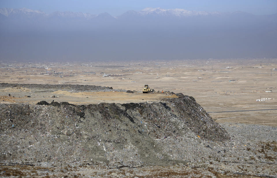 In this Wednesday, Oct. 23, 2019 photo, loaders work at the Kabul Municipality dump yard on the outskirts of Kabul, Afghanistan. Authorities are trying to tackle pollution in the country’s capital, which may be even deadlier than 18-year-old war. Most days a layer of smog covers Kabul, and it gets worse in the winter, when people burn coal, garbage, plastic and rubber to heat their homes. (AP Photo/Rahmat Gul)