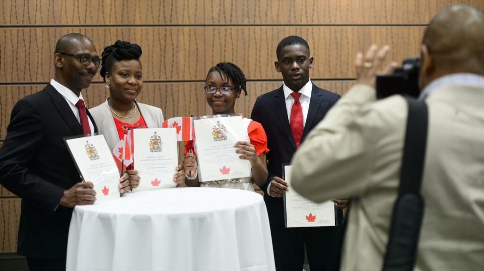 A Haitian family poses for a photo after becoming new Canadians following a citizenship ceremony on Parliament Hill in 2019. THE CANADIAN PRESS/Sean Kilpatrick