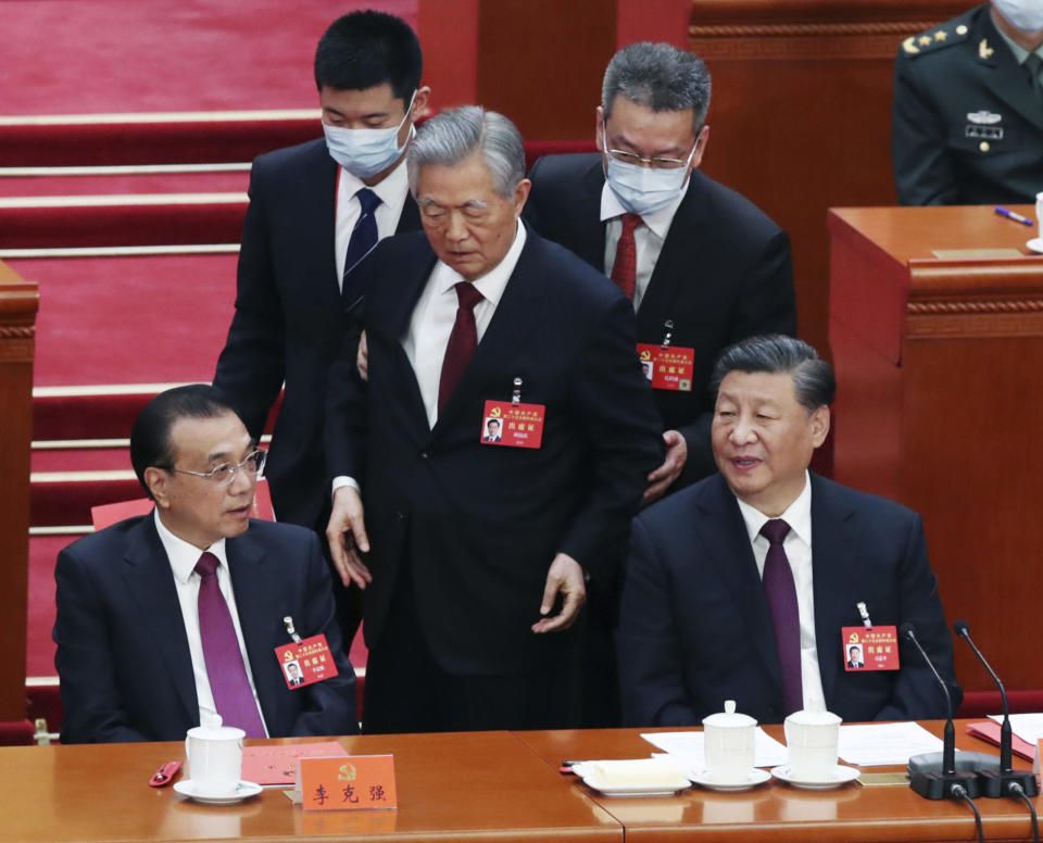 Zwei Parteikader geleiten Hu Jintao vor Xi Jinpings Augen vom Parteitag der Kommunistischen Partei – nun ist der ehemalige Partei- und Staatschef wieder aufgetaucht. - Copyright: picture alliance/AP/Koki Kataoka