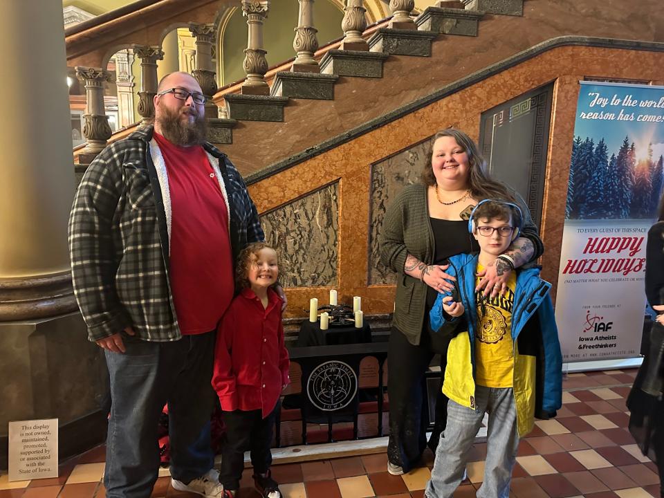 The Grimm family poses in front of the display in the Capitol.