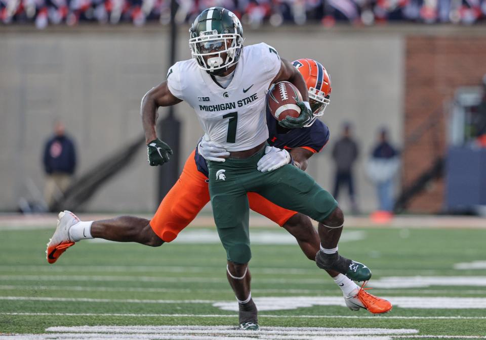 Jayden Reed (1) of the Michigan State Spartans runs the ball as Jartavius Martin (21) of the Illinois Fighting Illini tries to make the tackle from behind during the second half at Memorial Stadium on November 5, 2022 in Champaign, Illinois.