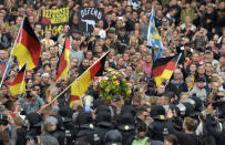 Protesters carry a wreath as they gather for a far-right protest in Chemnitz, Germany, Monday, Aug. 27, 2018 after a man has died and two others were injured in an altercation between several people of "various nationalities" in the eastern German city of Chemnitz on Sunday. (AP Photo/Jens Meyer)