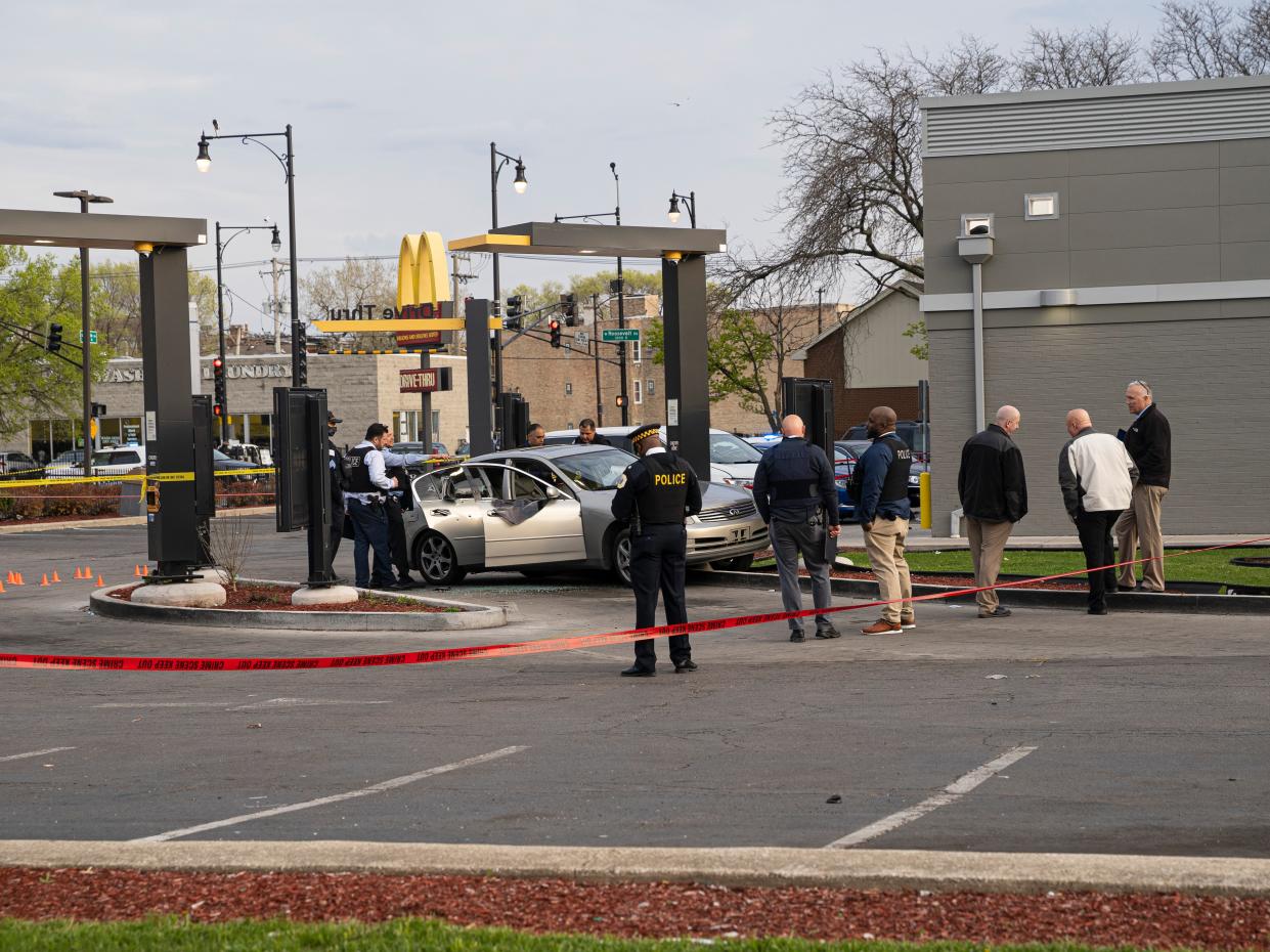 <p>Police investigate a crime scene where Jontae Adams, 28, and his daughter Jaslyn, seven, where shot, resulting in Jaslyn’s death at a McDonald’s drive-thru, Sunday, 18 April, 2021</p> (AP)