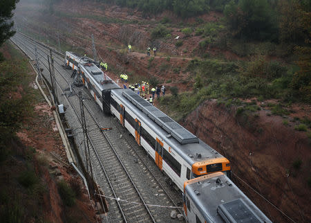 Rescue workers survey the scene after a commuter train derailed between Terrassa and Manresa, outside Barcelona, Spain, November 20, 2018. REUTERS/Albert Gea