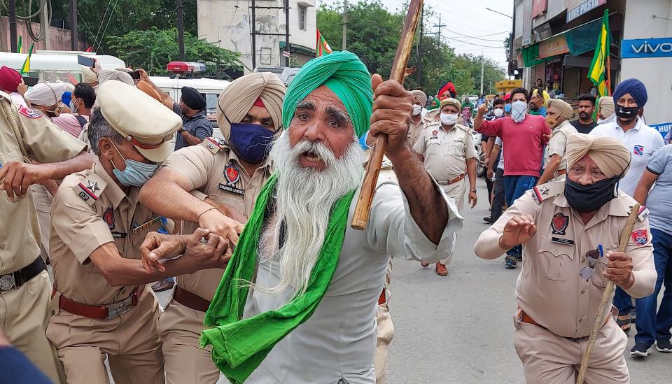 Police attempt to detain a farmer during a protest against BJP leaders in Patiala, Thursday, 22 April 2021.