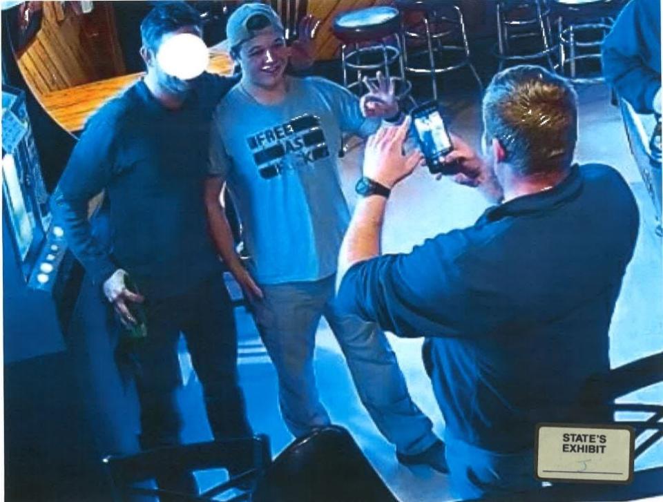 Kenosha shooting suspect Kyle Rittenhouse is seen in Pudgy's Pub in Mount Pleasant on Jan. 5 posing for a photo while flashing a white power sign.