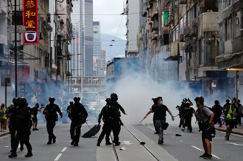 Riot police fire tear gas into the crowds to disperse anti-national security law protesters during a march at the anniversary of Hong Kong's handover to China from Britain in Hong Kong