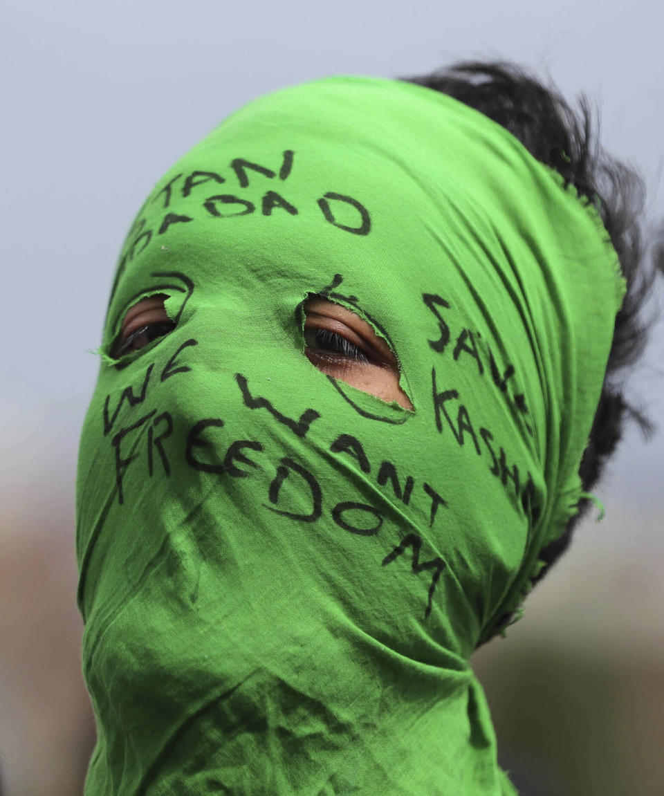 FILE- In this Friday, Aug. 30, 2019, file photo, a masked Kashmiri protester shouts freedom slogans in Srinagar, Indian controlled Kashmir. Frustration, anger and fear have been growing in Kashmir in the five weeks since the Hindu nationalist government of Prime Minister Narendra Modi stripped the region of most of its semiautonomous status on Aug. 5 and imposed a curfew and a communications blackout. Although some restrictions have been eased in the main city of Srinagar, with students encouraged to return to school and businesses to reopen, rural residents complain of what they perceive as a campaign of violence and intimidation that seems designed at suppressing any militancy, rebellion or dissent. (AP Photo/Mukhtar Khan, File)