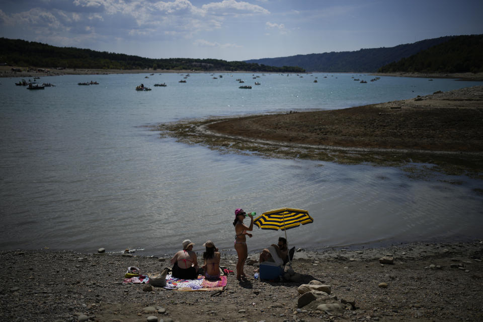 FILE - A bather drinks water at a drying bank of the Verdon Gorge, southern France, Aug. 9, 2022. What's considered officially “dangerous heat” in coming decades will likely hit much of the world at least three times more often as climate change worsens, according to a new study. (AP Photo/Daniel Cole, File)