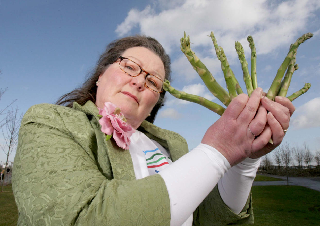 Jemima Packington holding a bunch of asparagus stalks. [Photo: SWNS]