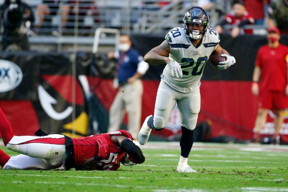 Seattle Seahawks running back Rashaad Penny (20) breaks a tackle against Arizona Cardinals outside linebacker Chandler Jones, left, during the first half of an NFL football game Sunday, Jan. 9, 2022, in Glendale, Ariz. (AP Photo/Ralph Freso)