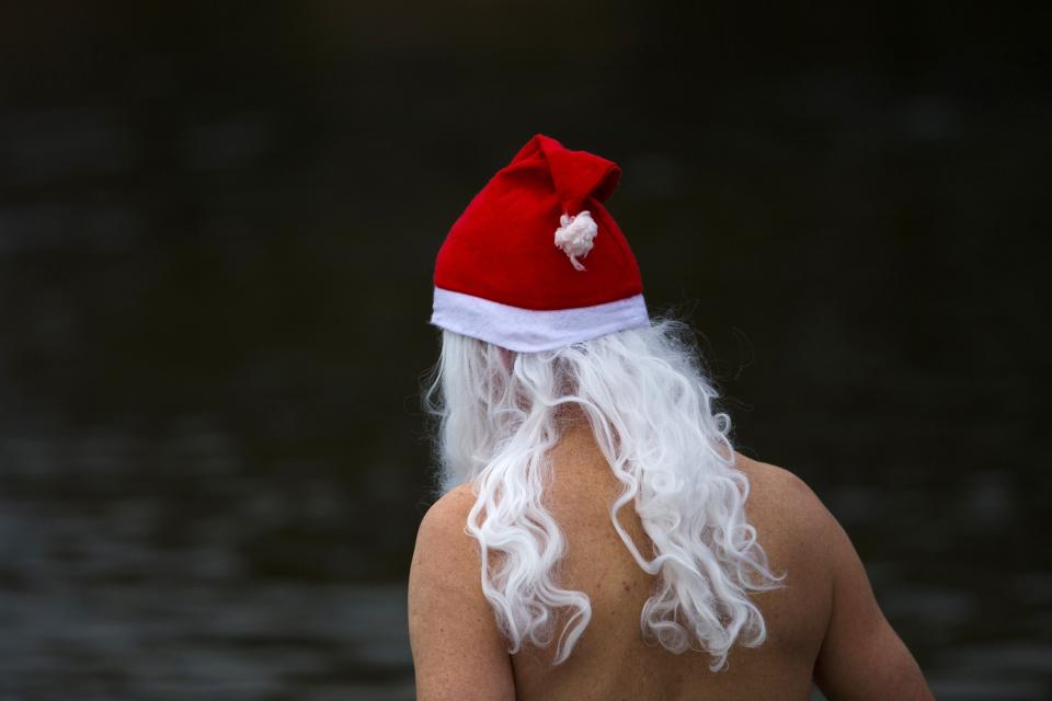 Member of ice swimmers club takes dip in lake during their traditional Christmas swimming event in Berlin