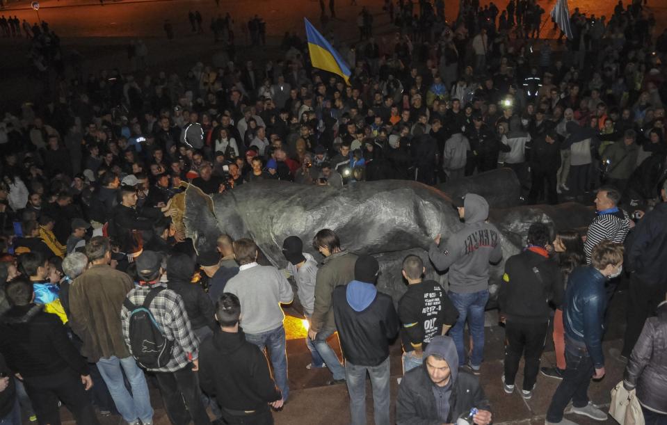 People surround a statue of Soviet state founder Vladimir Lenin (C), which was toppled by protesters during a rally organized by pro-Ukraine supporters in the centre of the eastern Ukrainian town of Kharkiv September 28, 2014. Picture taken September 28, 2014. REUTERS/Stringer (UKRAINE - Tags: POLITICS CIVIL UNREST)