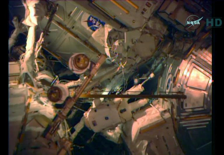NASA video image of spacewalk during which astronauts will set up antennas and communications equipment so future crews will be able to park at the space station