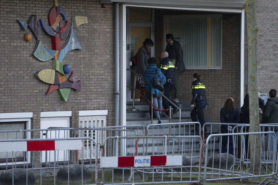 Two Dutch police officers enter the high security court building where the trial opens in Amsterdam, Netherlands, Tuesday, Jan. 23, 2024, for suspects in the slaying of campaigning Dutch journalist Peter R. De Vries. A long-delayed trial opened Tuesday of nine men accused of involvement in the fatal shooting on a downtown Amsterdam street of Dutch investigative reporter de Vries. (AP Photo/Peter Dejong)