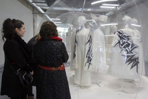 Women look at creations by Japanese designer Rei Kawakubo for Comme des Garcons fashion house April 11, 2012 in Paris. It is a rare privilege to be able to see not just one or two models but a complete collection, and what is more, bang up to date, for spring-summer 2012, fresh off the catwalks last October