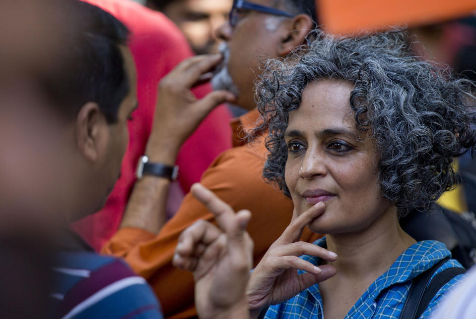 FILE - Writer and activist Arundhati Roy, right, talks to a student during a march to the Indian parliament house in New Delhi, India March 15, 2016. “Most former colonies have struggled to put a lasting democratic process in place. India was more successful than most in doing that,” said the Booker Prize-winning novelist and activist. “And now, 75 years on, to witness it being dismantled systematically and in shockingly violent ways is traumatic.” (AP Photo/Manish Swarup, File)