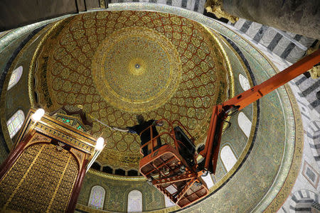 An employee of the Jordanian Waqf, or Islamic trust, that oversees the area, stands on a crane as he cleans the ceiling during preparations ahead of the Muslim holy month of Ramadan, in the Dome of the Rock located on the compound known to Muslims as al-Haram al-Sharif and to Jews as Temple Mount, in Jerusalem's Old City, April 19, 2017. REUTERS/Ammar Awad