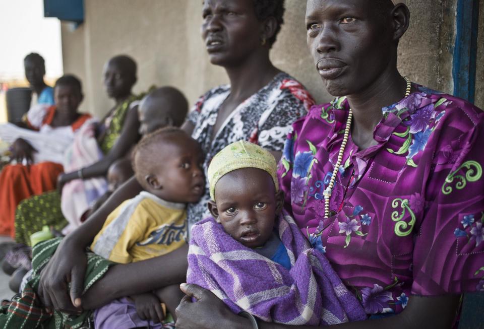 Displaced mothers and their babies who fled from recent fighting in Bor, many of whom are suffering from dehydration and diarrhea due to the lack of any sanitation, queue outside a clinic run by Medecins Sans Frontieres (Doctors Without Borders) set up in a school building in the town of Awerial, South Sudan Thursday, Jan. 2, 2014. The international Red Cross said Wednesday that the road from Bor to the nearby Awerial area "is lined with thousands of people" waiting for boats so they could cross the Nile River and that the gathering of displaced is "is the largest single identified concentration of displaced people in the country so far". (AP Photo/Ben Curtis)