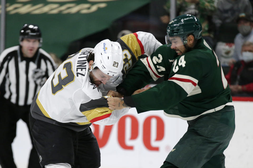 Minnesota Wild defenseman Matt Dumba (24) and Vegas Golden Knights defenseman Alec Martinez (23) fight during the second period in Game 6 of an NHL hockey Stanley Cup first-round playoff series Wednesday, May 26, 2021, in St. Paul, Minn. (AP Photo/Andy Clayton-King)