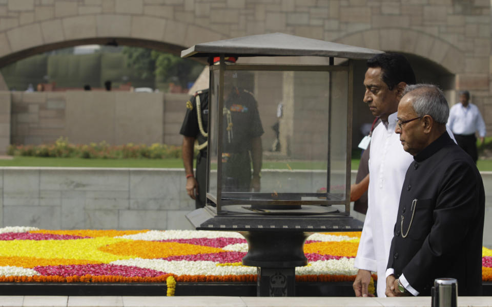 Political veteran Pranab Mukherjee, right, arrives to pay homage at Rajghat, the memorial to the late Mahatma Gandhi, in New Delhi, India, Wednesday, July 25, 2012. Mukherjee was sworn in Wednesday as India's 13th president in an elaborate and symbolic ceremony in Parliament. (AP Photo/Altaf Qadri)