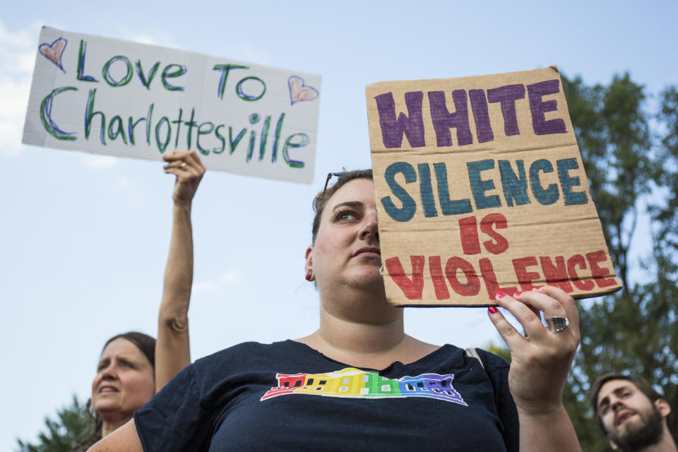 Demonstrators hold signs outside the White House on Aug. 13 during a vigil in response to the death of a counterprotester in the Aug. 12 "Unite the Right" rally.