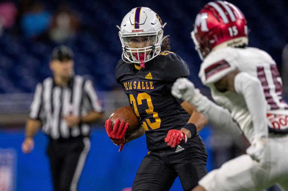 Warren De La Salle's Phoenix Glassnor runs the ball against a Muskegon defender during the Division 2 football state championship game at Ford Field in Detroit on Saturday, Nov. 25, 2023.