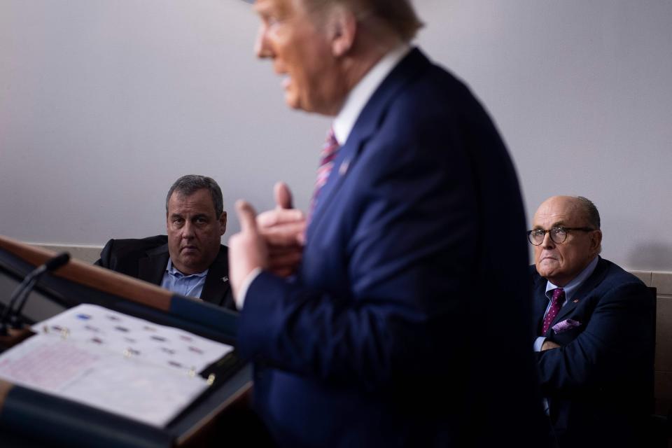 Former New Jersey Governor Chris Christie and former New York City Mayor Rudy Giuliani listen while President Donald Trump speaks during a briefing at the White House in Washington, Sept. 27, 2020.