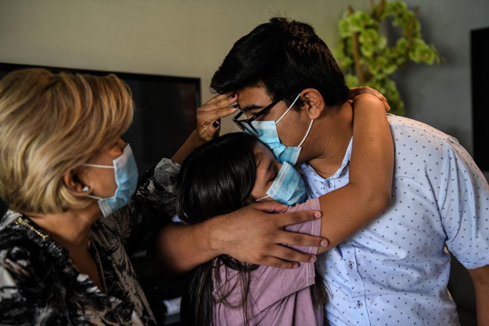 Glenda Amaya, con sus hijos Azareth y Germán. Germán Amaya padre dejó una familia devastada, que llora su muerte mientras se enfrenta a una factura de hospital impagable.. (Photo by CHANDAN KHANNA / AFP) (Photo by CHANDAN KHANNA/AFP via Getty Images)