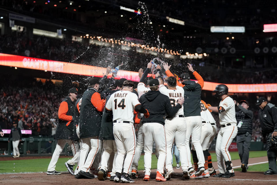 San Francisco Giants players celebrate after Mike Yastrzemski hit a three-run home run during the 10th inning of a baseball game against the San Diego Padres in San Francisco, Monday, June 19, 2023. The Giants won 7-4 in 10 innings. (AP Photo/Jeff Chiu)