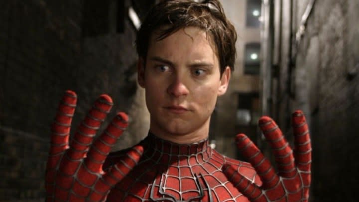 Mask-less Spider-Man looking at his hands with confusion in "Spider-Man 2."