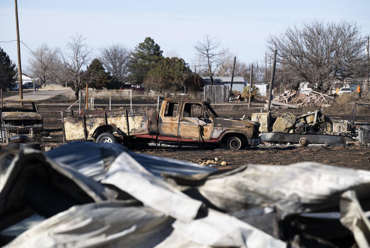 A burned truck sits on lot in Fritch where the fire went through while areas behind appear to be untouched Friday, March. 1, 2024.