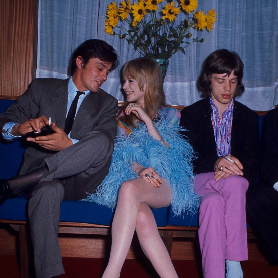 Delon and Marianne Faithfull talk in 1968, as Mick Jagger, her then-boyfriend, sits quietly to her left