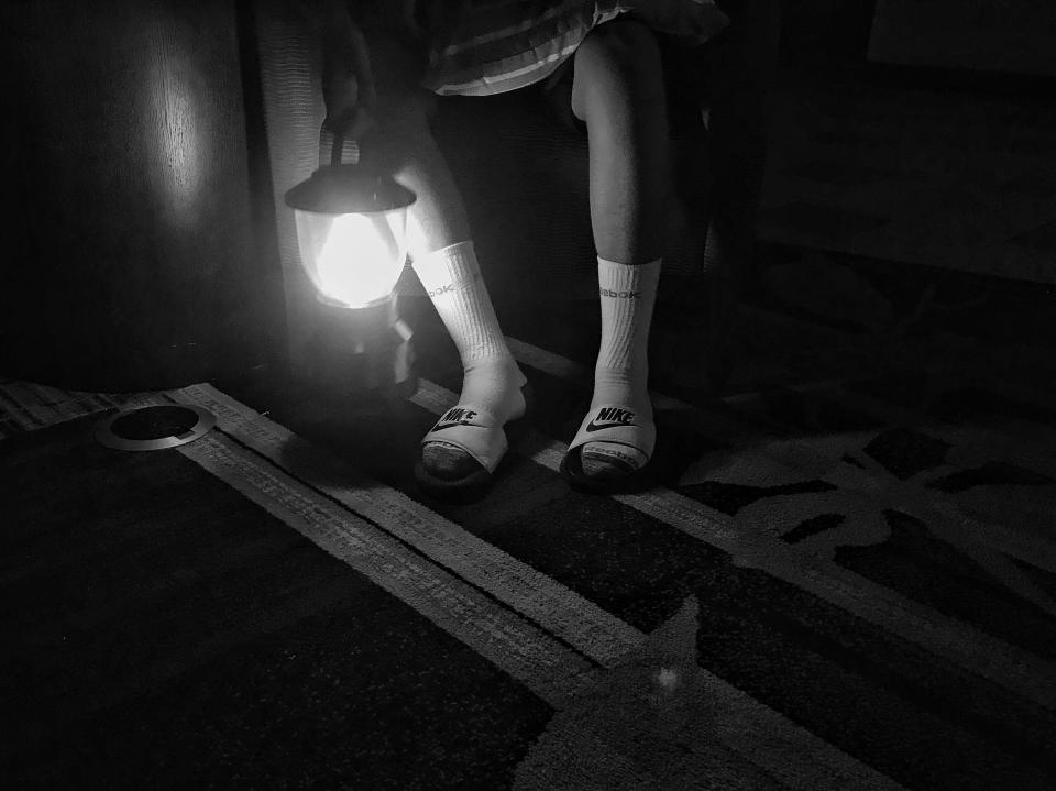 A boy sits with a lantern flashlight after a hotel lost power during Hurricane Irma. (Photo: Holly Bailey/Yahoo News)