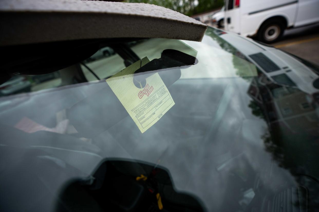 A Crow Tow parking pass hangs in the window of Joe Ward's vehicle at Aspen Apartments in Des Moines.