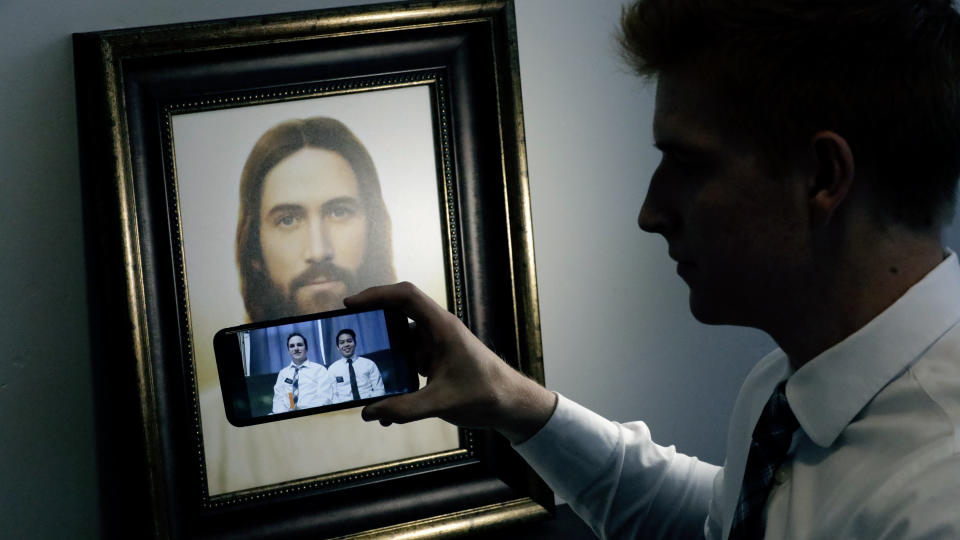 In this May 27, 2020, photo, from Seth Rather, a missionary with The Church of Jesus Christ of Latter-day Saints, looks at his smartphone at his apartment, in Brigham City, Utah. After hastily bringing home 26,000 young men and women who were serving in foreign countries, the faith has begun sending many of them out again in their home countries with a new focus on online work that could stick even when the pandemic is over, church officials told The Associated Press. For safety reasons missionaries are now inside and on their smartphones most of the day trying to find new converts or bolster the faith of current church members. (AP Photo/Rick Bowmer)