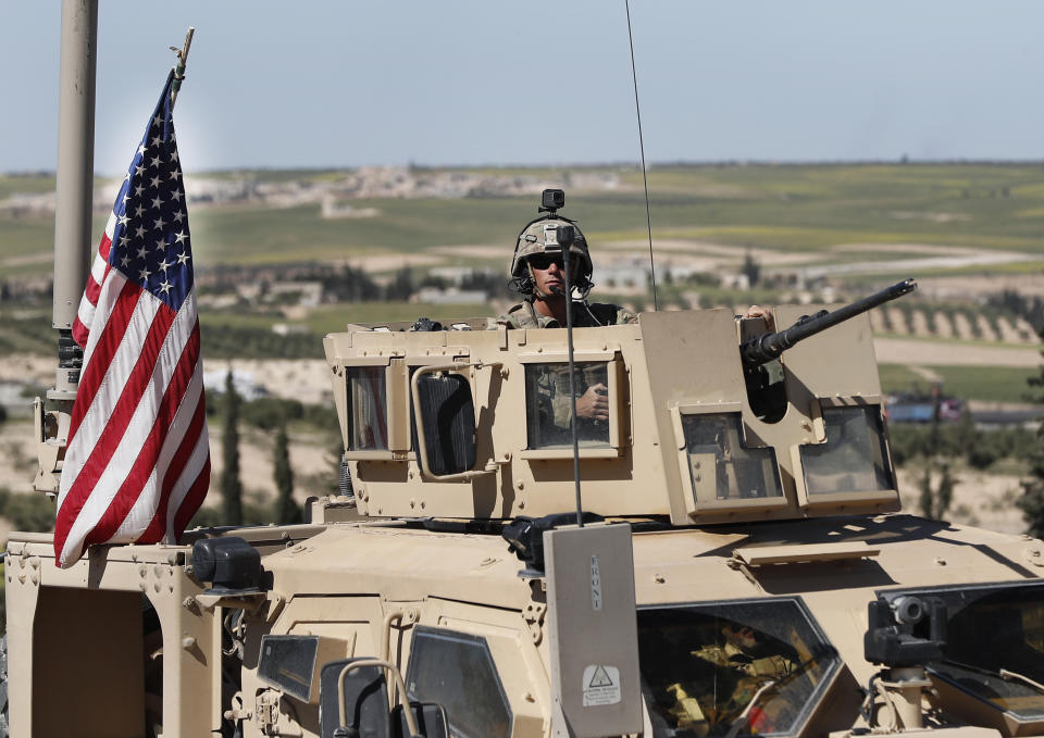 FILE -- In this April 4, 2018 file photo, a U.S. soldier sits in an armored vehicle on a road leading to the tense front line with Turkish-backed fighters, in Manbij, north Syria. The spokesman of the Manbij Military Council, a U.S.-backed militia, said Thursday Nov. 1, 2018, that joint U.S.-Turkish patrols will begin within hours around the northern Syrian town of Manbij, part of a roadmap for easing tensions between the two NATO allies. Ankara and Washington agreed on a roadmap in June amid Turkish demands for the withdrawal of the U.S.-backed Kurdish militia that freed Manbij from the Islamic State group in 2016. (AP Photo/Hussein Malla, File)