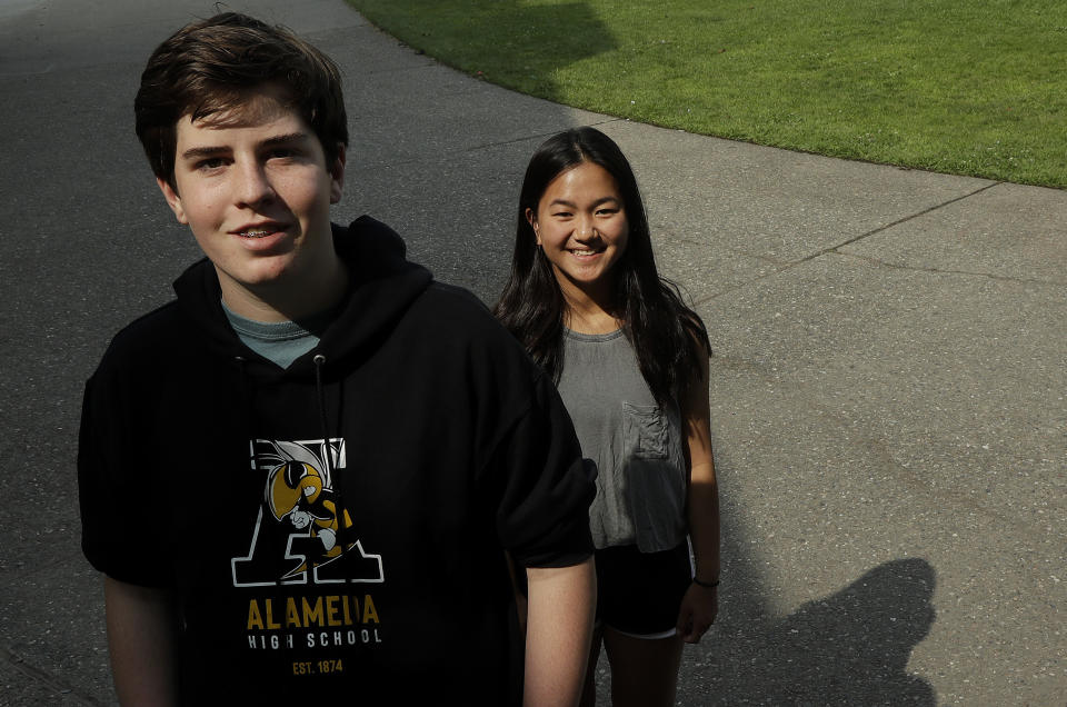 Alameda High School students Henry Mills, left, and Kristen Wong pose for photos on the school's campus in Alameda, Calif., Thursday, Aug. 23, 2018. The relaxed new dress code at public schools in the small city of Alameda, across the bay from San Francisco, is intentionally specific: Midriff-baring shirts are acceptable attire, so are tank tops with spaghetti straps and other once-banned items like micro-mini skirts and short shorts. (AP Photo/Jeff Chiu)