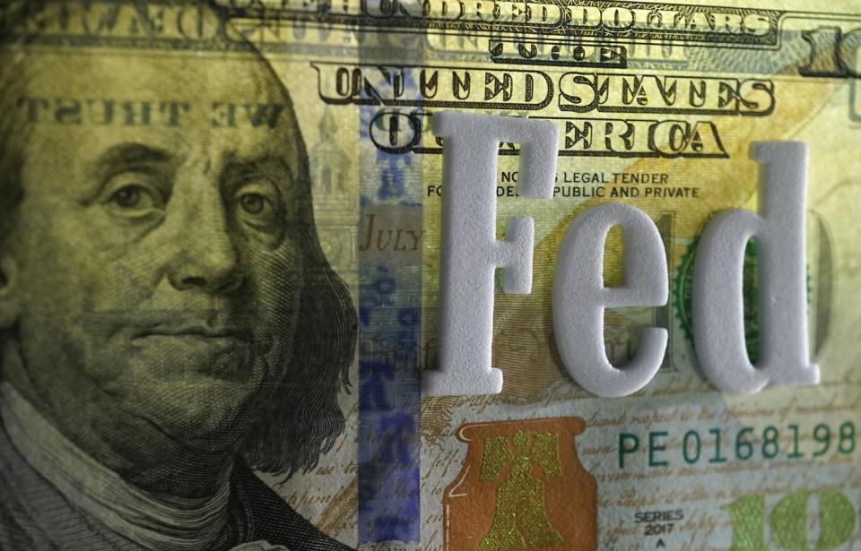 A $100 bill with the word "Fed" overlaid on it.