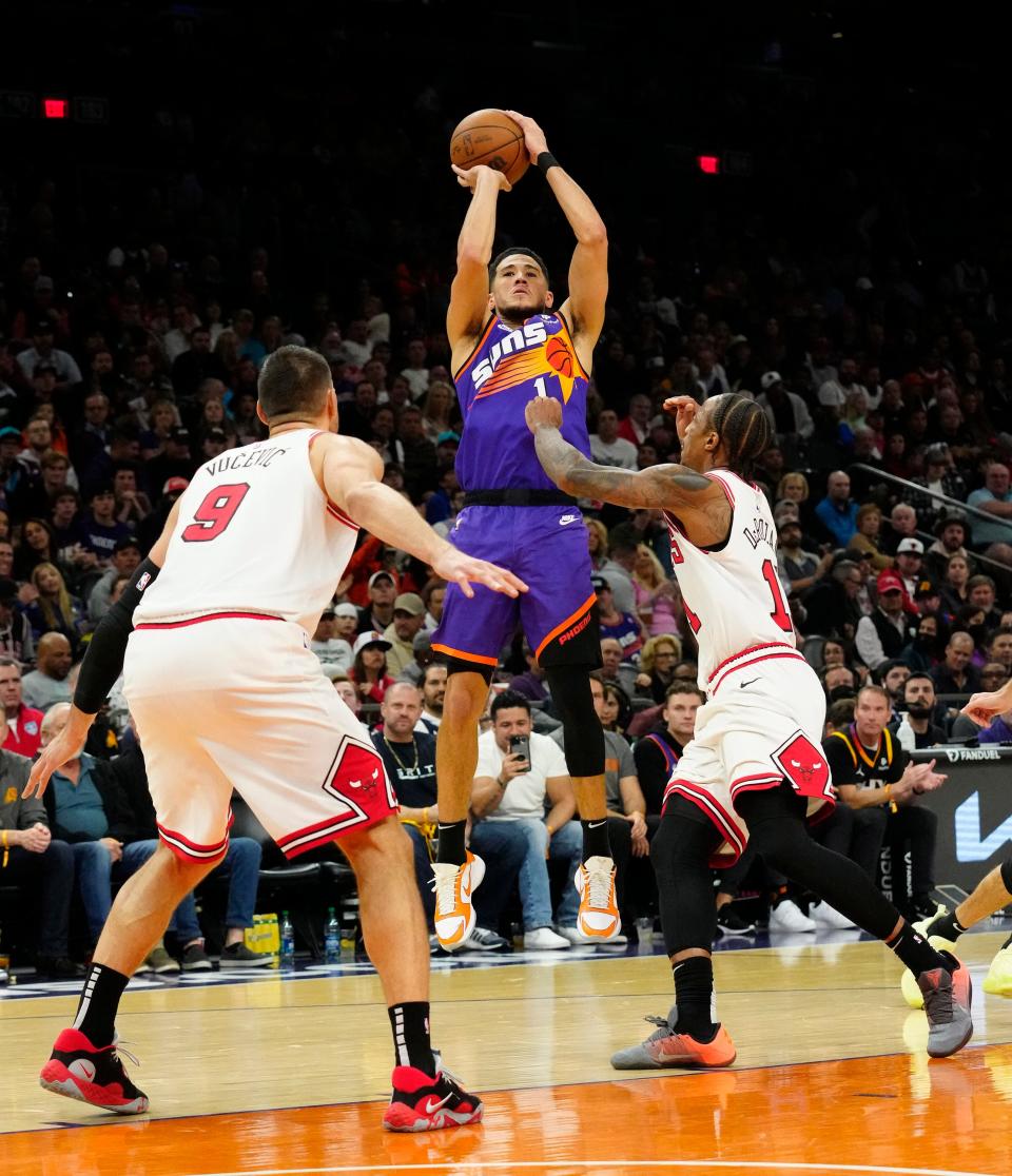 Nov 30, 2022; Phoenix, AZ, USA; Phoenix Suns guard Devin Booker (1) shoots a jumper over Chicago Bulls center Nikola Vucevic (9) in the second half at Footprint Center.
