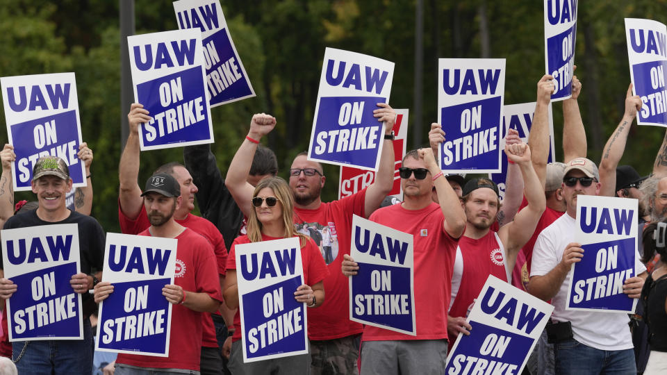 FILE - United Auto Workers members hold picket signs near a General Motors Assembly Plant in Delta Township, Mich., Sept. 29, 2023. As the auto workers strike approaches the one-month mark, more Americans sympathize with the striking workers than with the three big car companies that employ them. That's one of the findings in a new poll from The Associated Press-NORC Center for Public Affairs Research. (AP Photo/Paul Sancya)