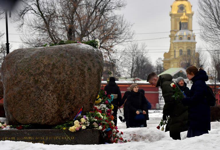 La gente deposita flores para el difunto líder de la oposición rusa Alexei Navalny en el monumento a las víctimas de la represión política en San Petersburgo 