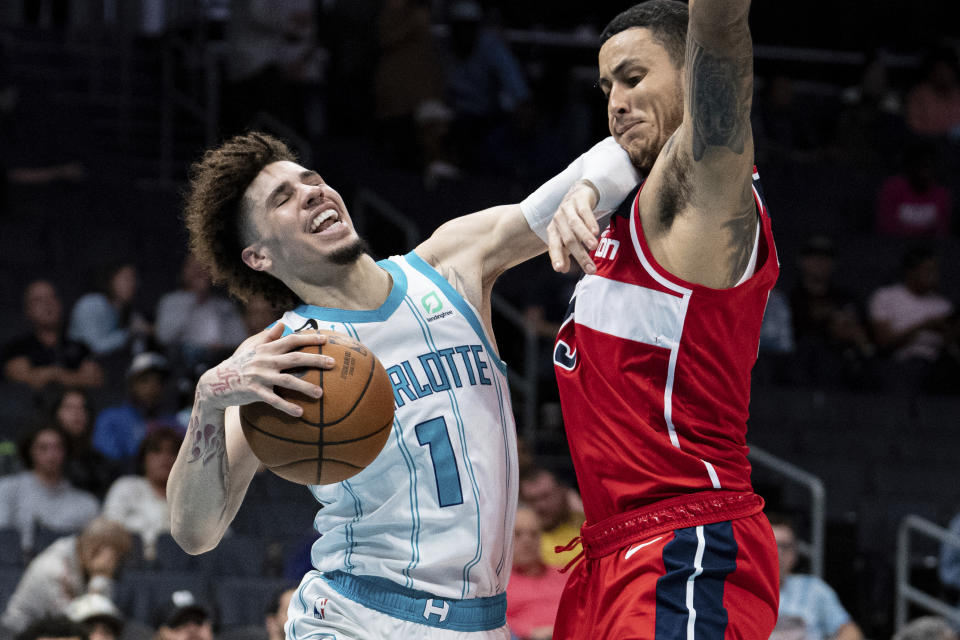 Charlotte Hornets guard LaMelo Ball (1) drives to the basket while guarded by Washington Wizards forward Kyle Kuzma in the first half of an NBA preseason basketball game in Charlotte, N.C., Monday, Oct. 10, 2022. (AP Photo/Jacob Kupferman)