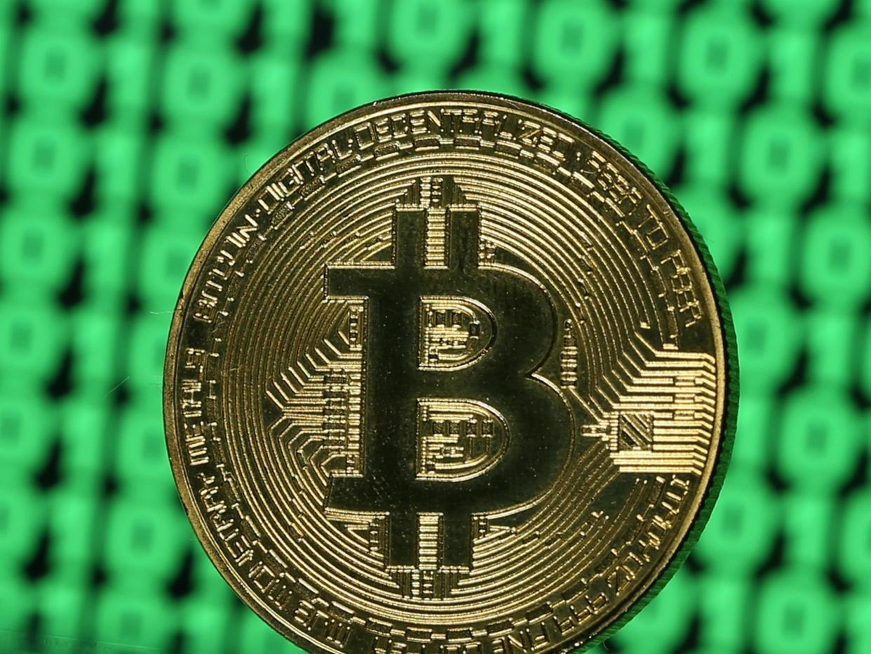 A token of the virtual currency Bitcoin is seen placed on a monitor that displays binary digits in this illustration picture, December 8, 2017: Reuters