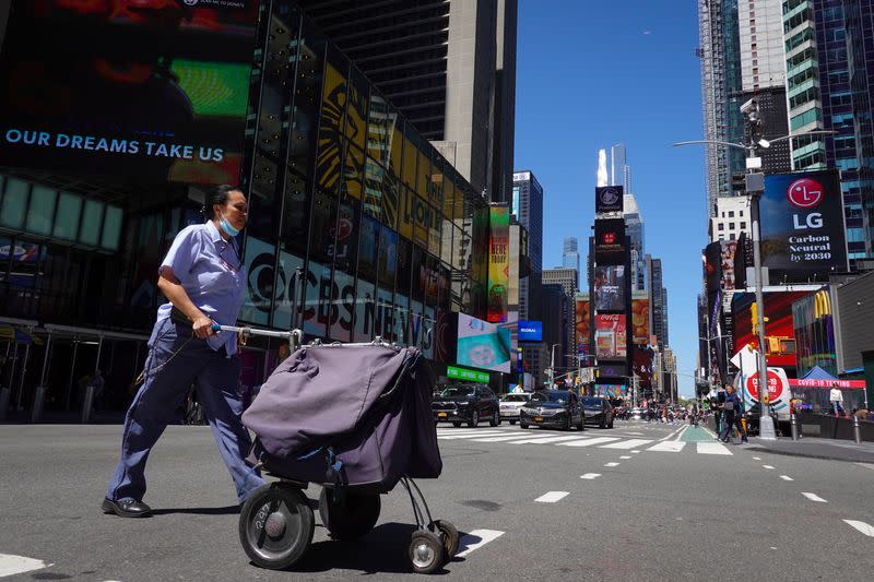 A United States Postal Service mail delivery person walks through Times Square in Manhattan, New York City