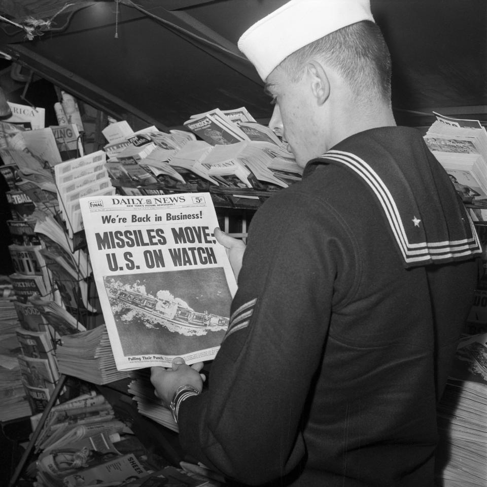 U.S. sailor reads the front page of the New York Daily News at a newsstand on November 9, 1962. (Photo: Getty Images)