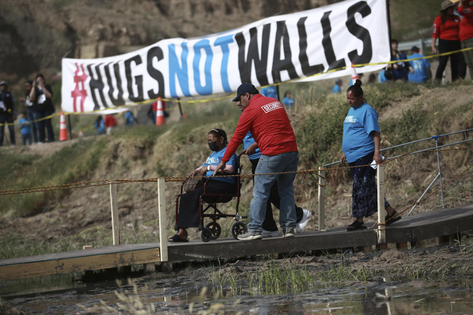 People living in Mexico cross a temporary bridge to meet with relatives living in the U.S., during the 10th annual "Hugs not Walls" event on a stretch of the Rio Grande, in Ciudad Juarez, Mexico, Saturday, May 6, 2023. The brief family reunions are part of a campaign sponsored by the Border Network for Human Rights, an immigration rights group. (AP Photo/Christian Chavez)